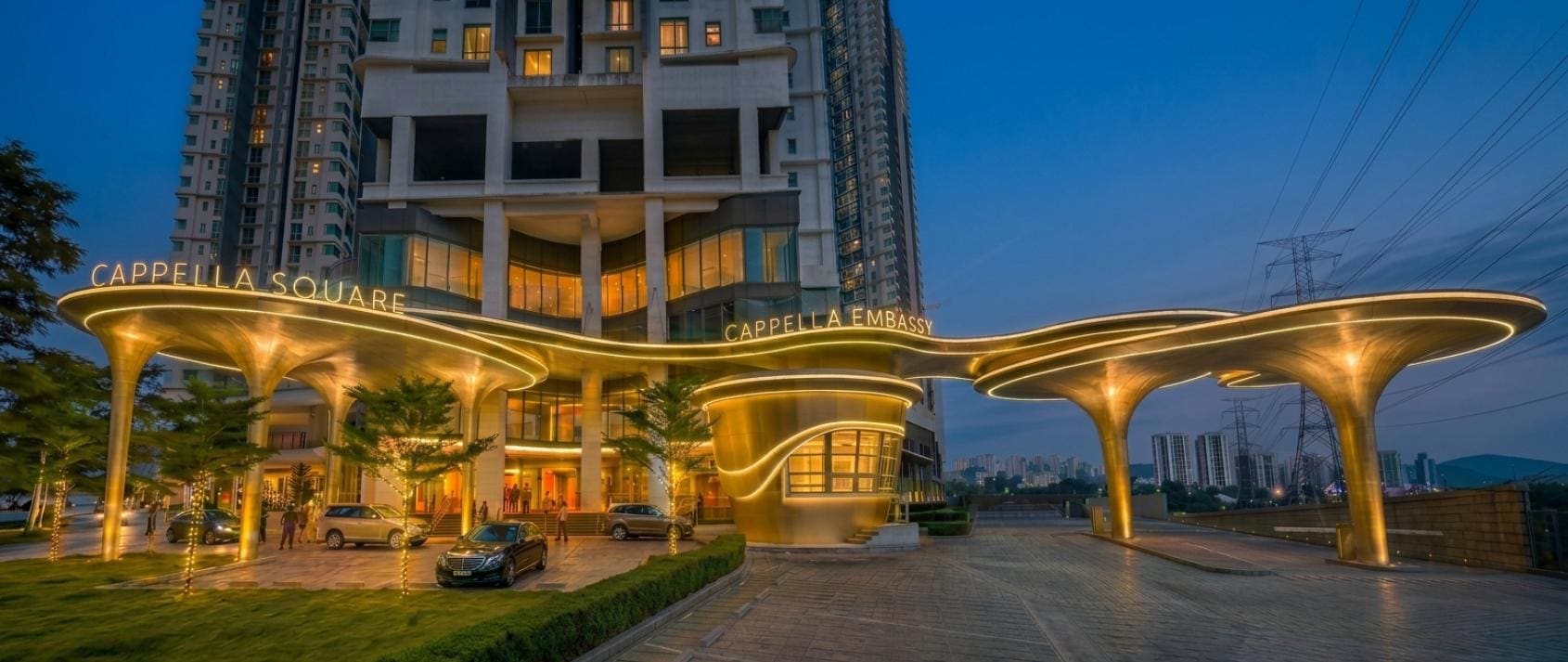 Illuminated Cappella Embassy and Cappella Square entrance canopies on Jalan Ampang at night — photograph
