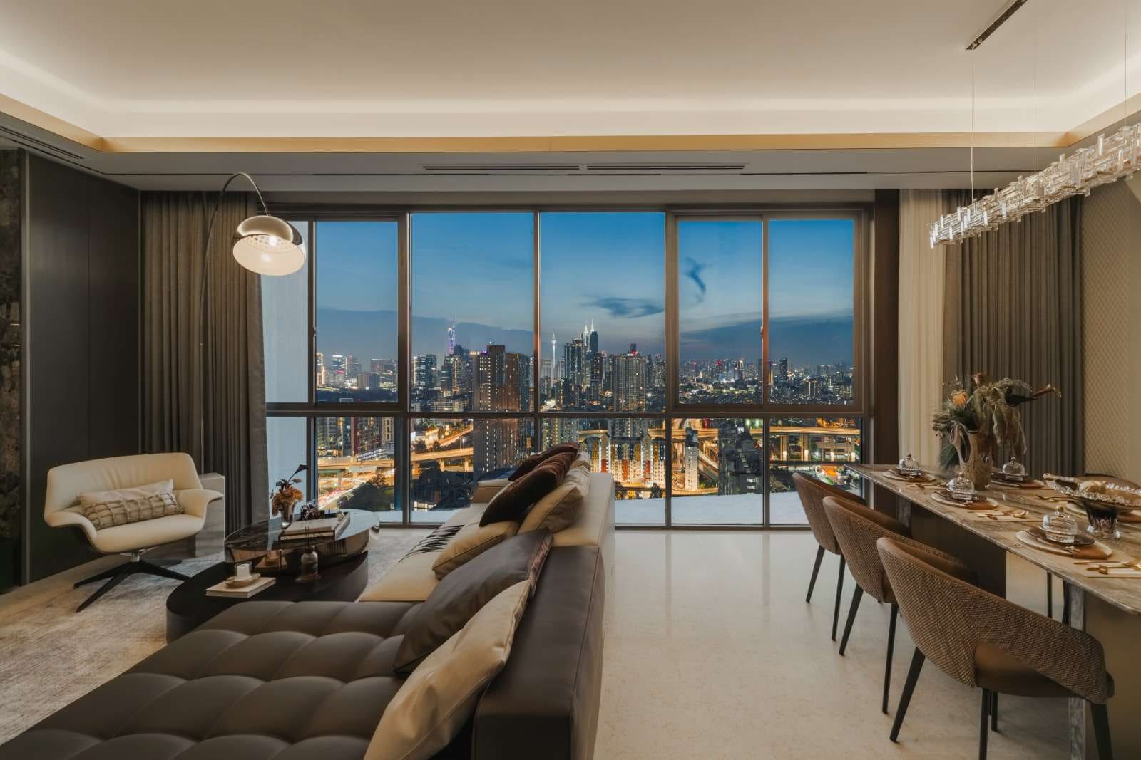 Type C show unit living area at dusk with the city lights beyond — show unit photograph